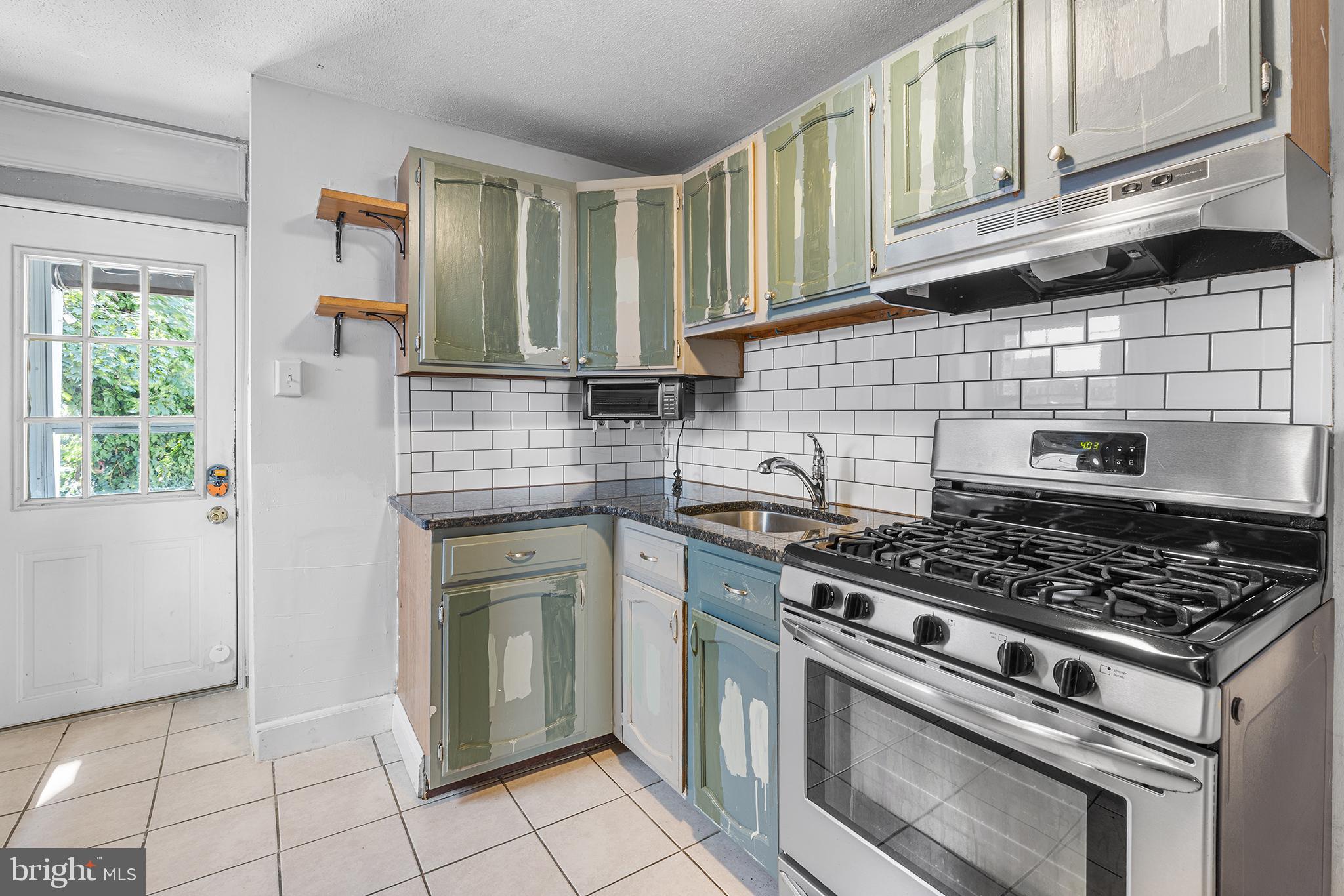 157 Cotton Street Philadelphia, PA 19127 - Photo 8 of 26 a kitchen with granite countertop a stove sink and cabinets