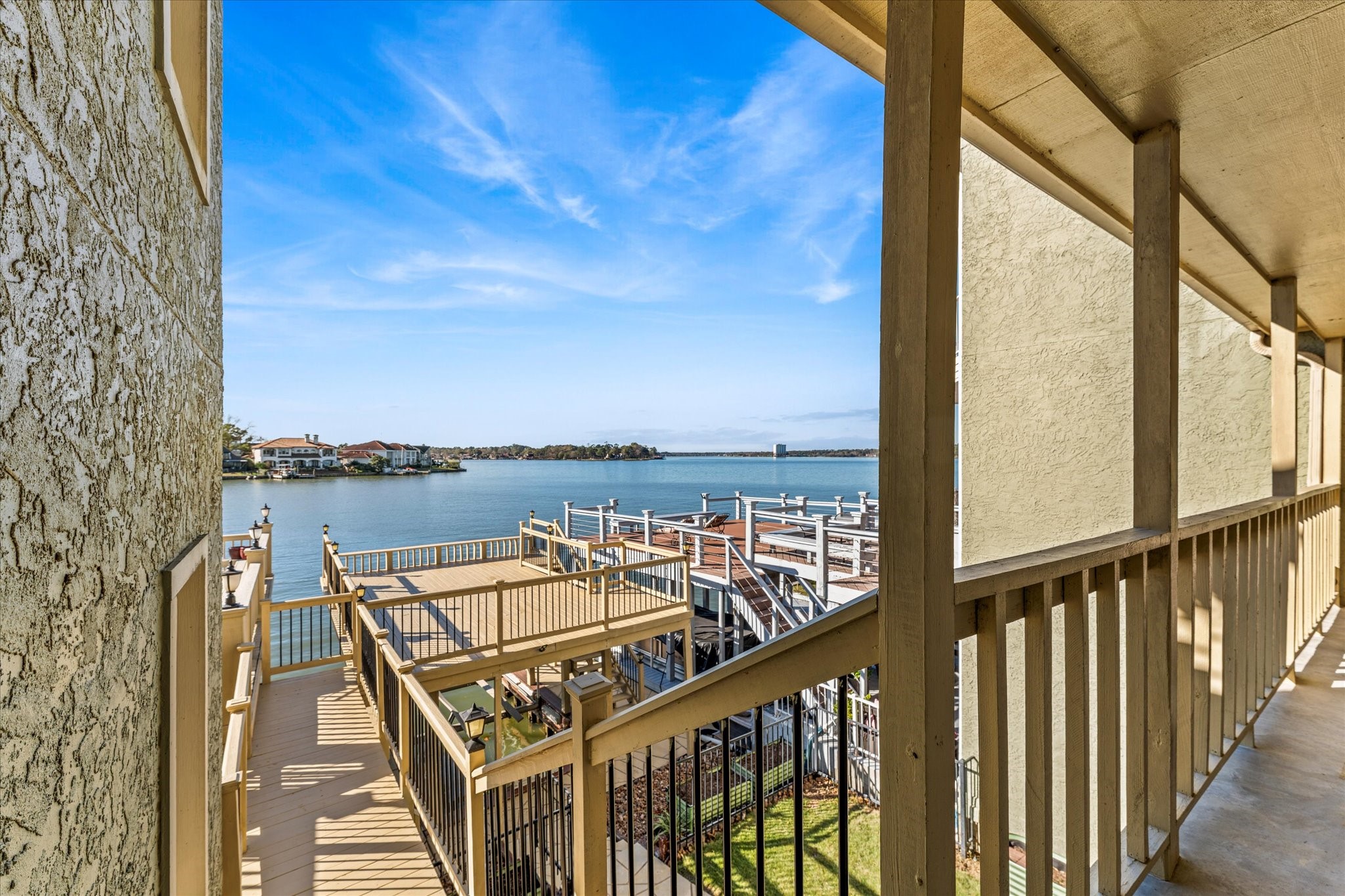 145 Capetown Way Conroe, TX 77356 - Photo 18 of 38 a view of a balcony with wooden chairs and floor to ceiling window