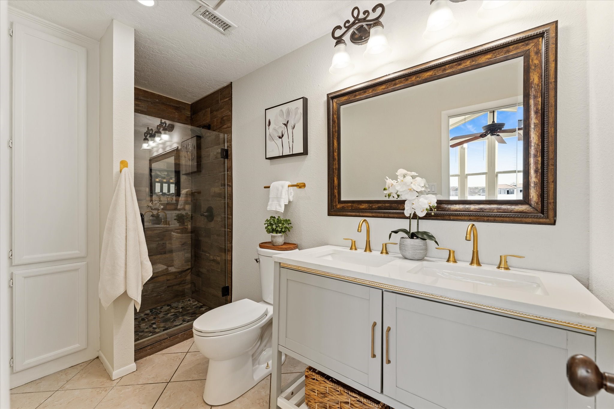 145 Capetown Way Conroe, TX 77356 - Photo 24 of 38 a bathroom with a double vanity sink toilet and shower