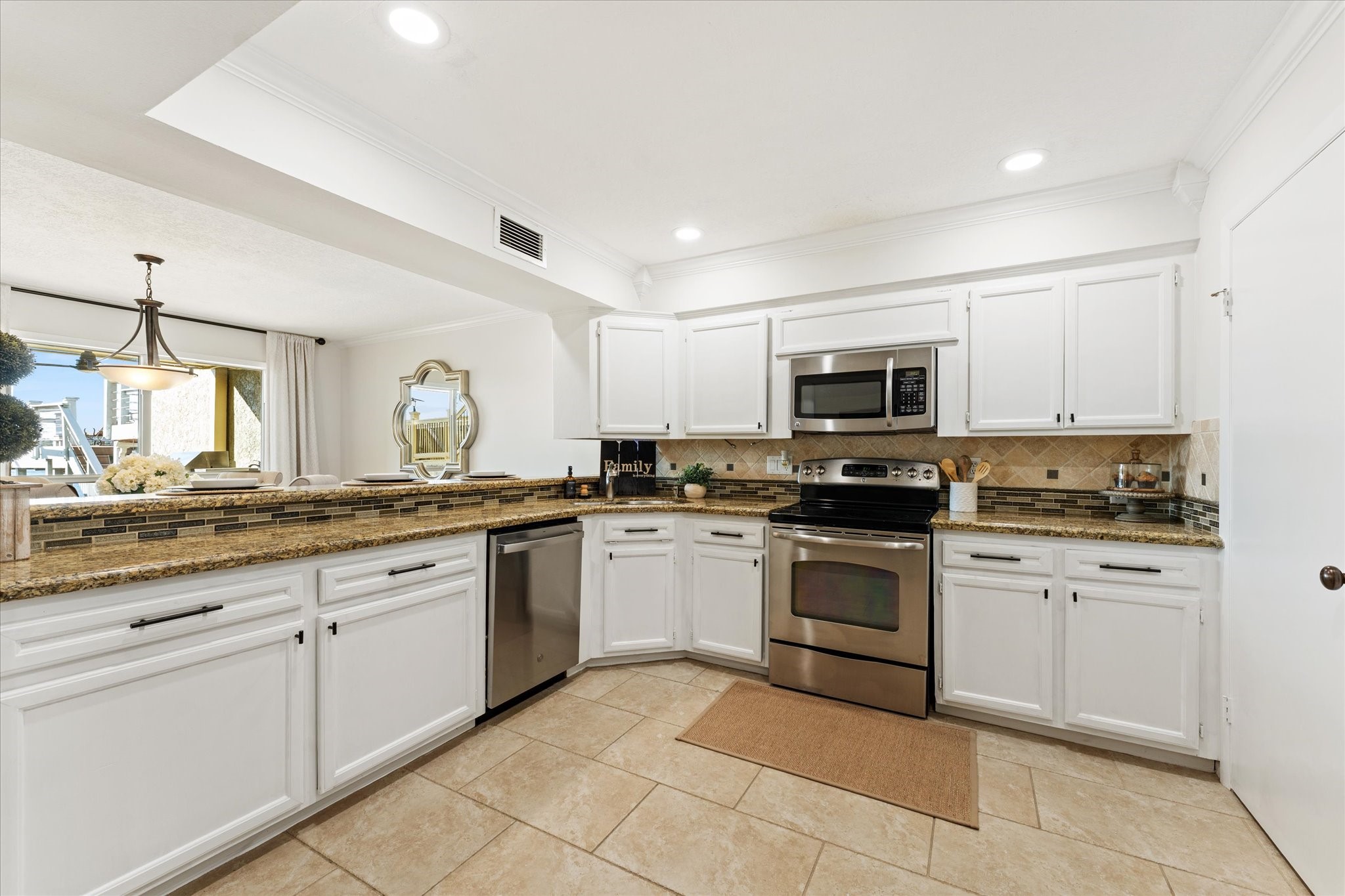 145 Capetown Way Conroe, TX 77356 - Photo 9 of 38 a kitchen with granite countertop white cabinets and stainless steel appliances
