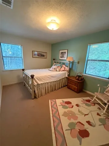 a view of swimming pool with lawn chairs with plants