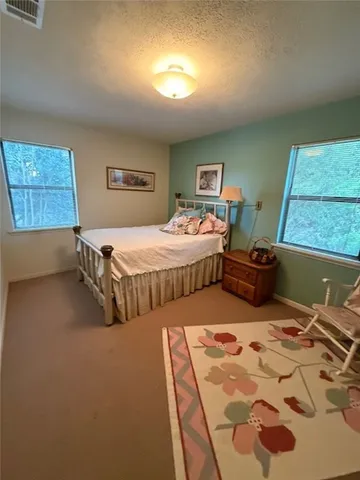 a view of swimming pool with lawn chairs with plants