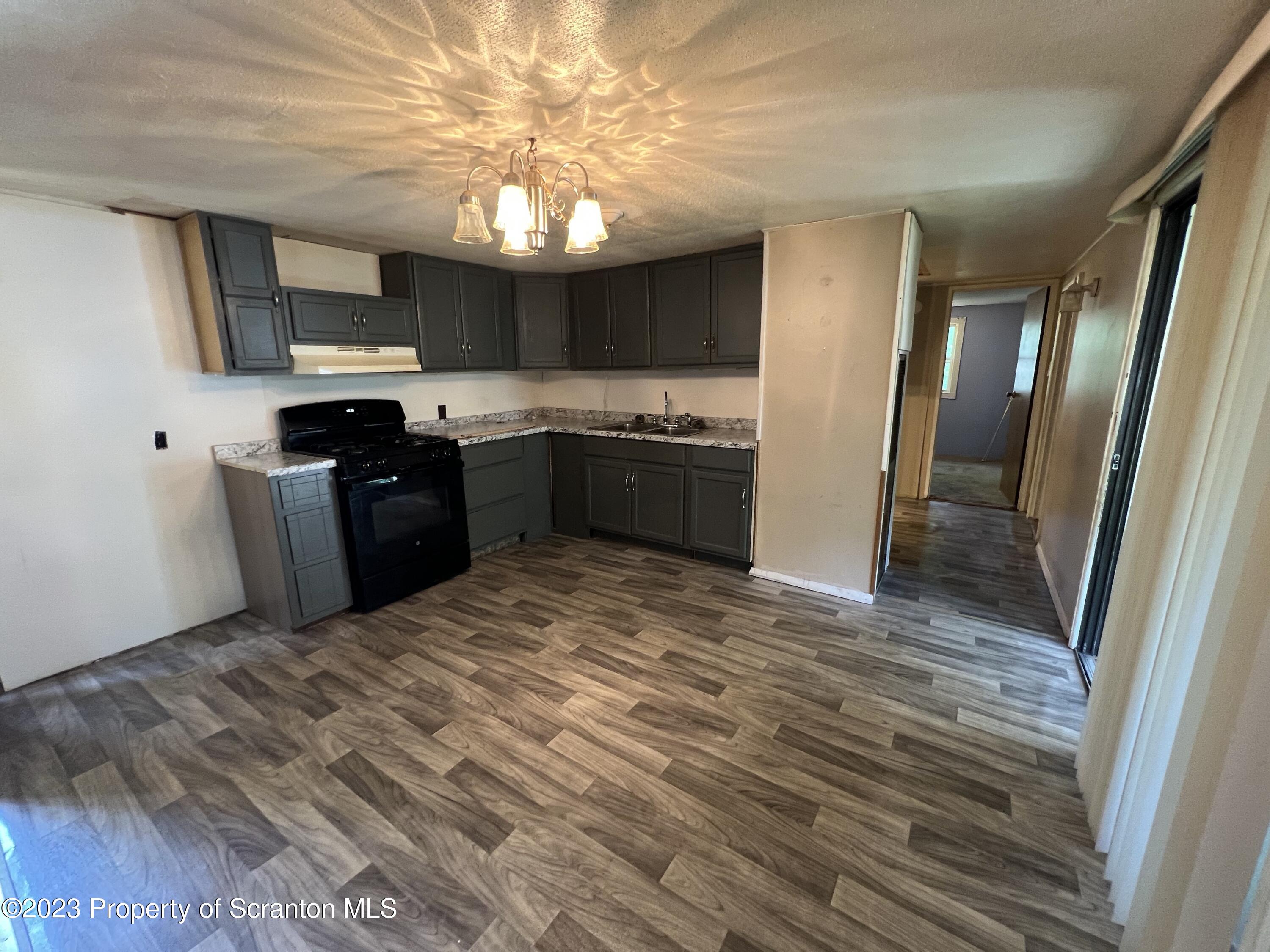 504 5th Street Avoca, PA 18641 - Photo 3 of 8 a large kitchen with a stove a refrigerator and a fireplace