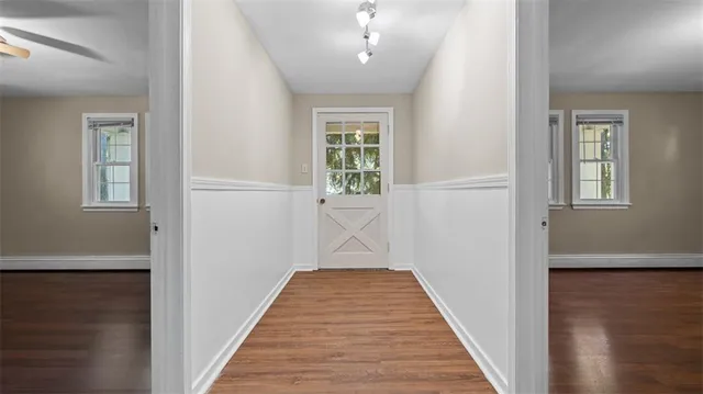 a view of a hallway with wooden floor and a living room