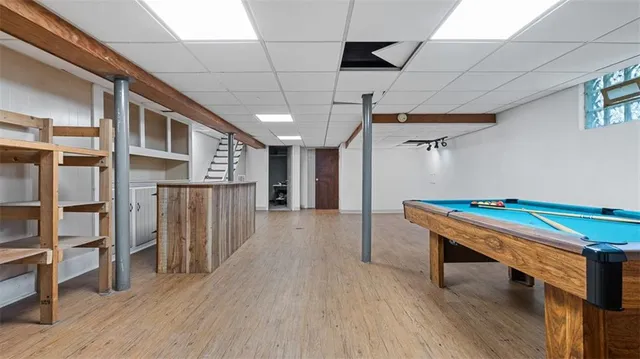 a room with wooden floors and pool table