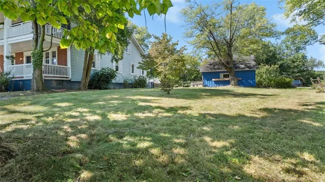 a view of a house with a yard and tree s
