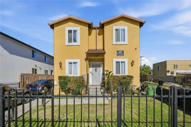 a view of a brick house with large windows next to a road