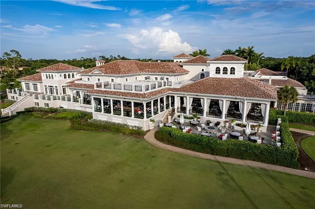 a view of a big house with a big yard and large trees