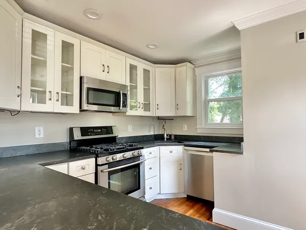 a kitchen with stainless steel appliances granite countertop a stove a sink and a microwave