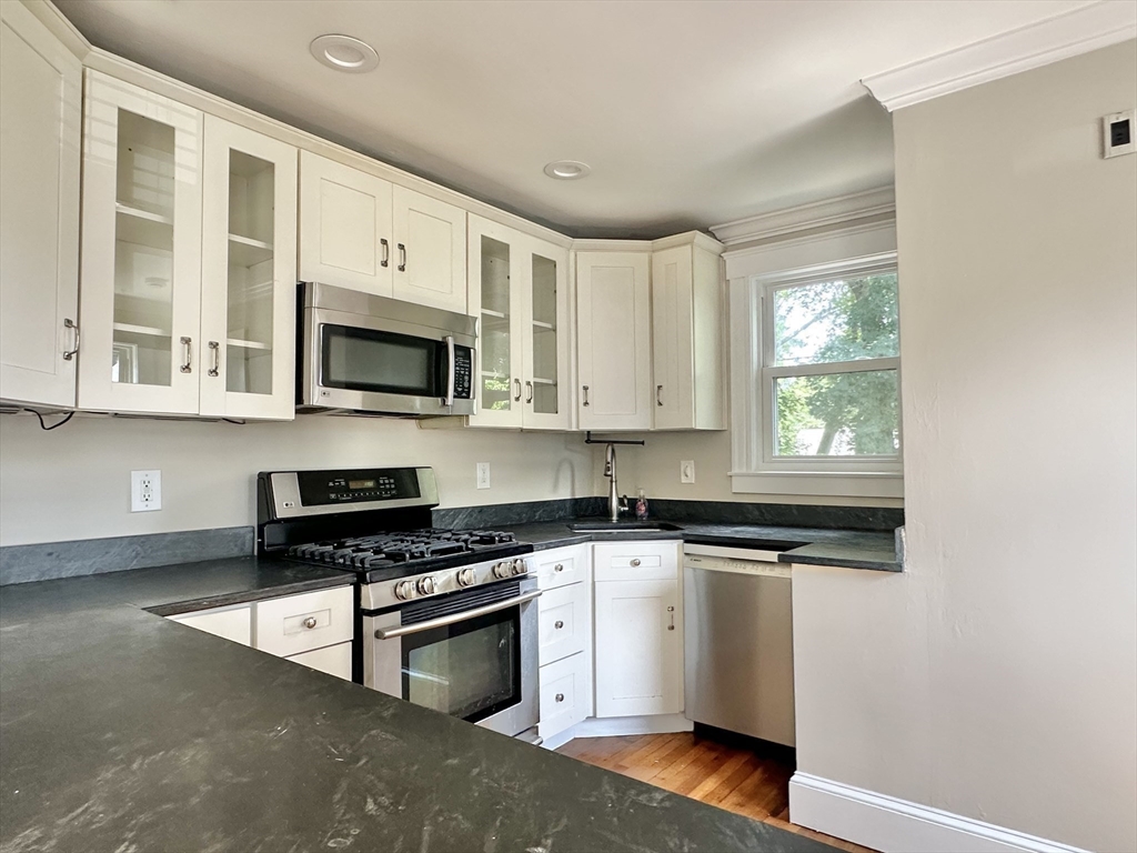 a kitchen with stainless steel appliances granite countertop a stove a sink and a microwave