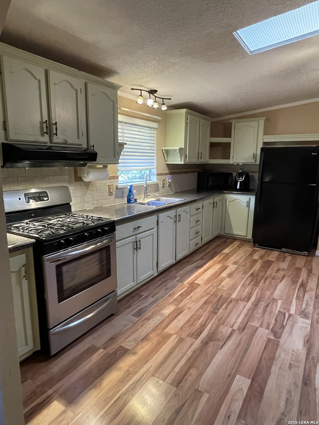 10280 Obrien Road Atascosa, TX 78002 - Photo 2 of 6 a kitchen with stainless steel appliances granite countertop a stove a sink and a microwave