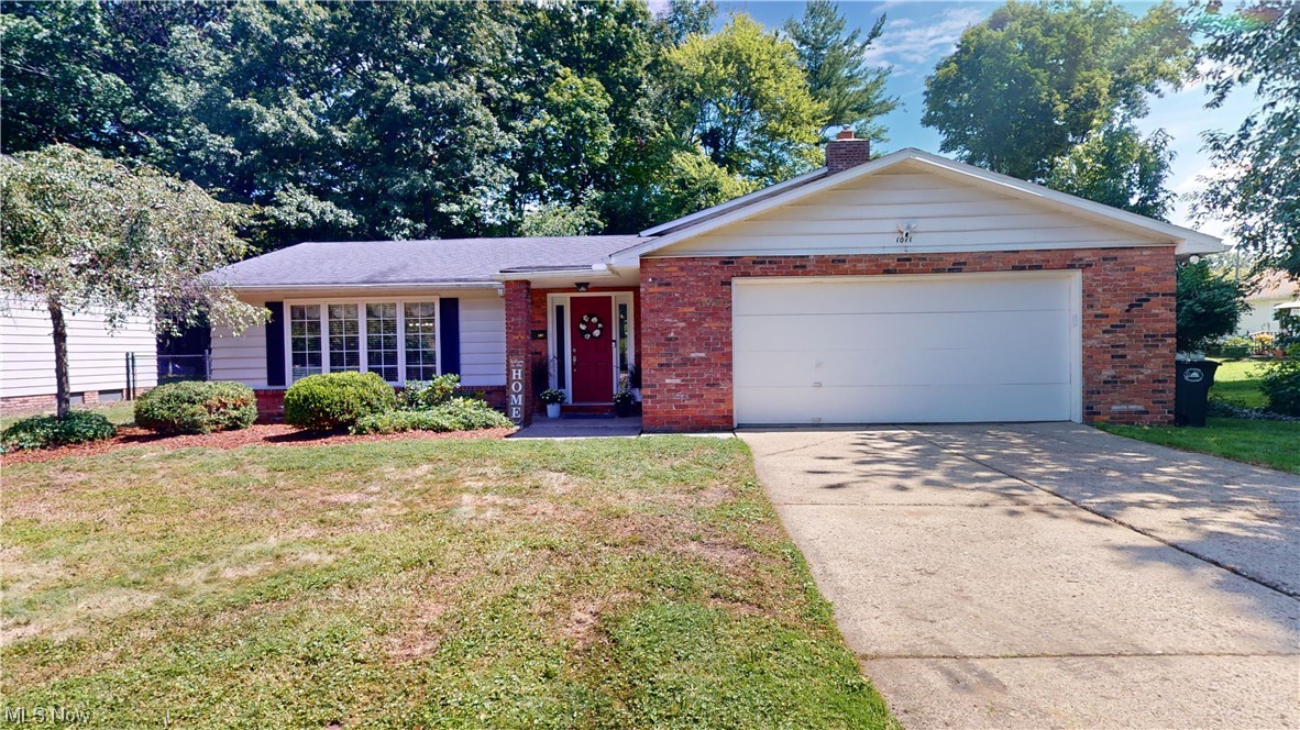 Ranch-style house with garage and a front lawn