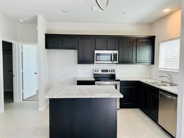 a kitchen with a sink a stove top oven and refrigerator