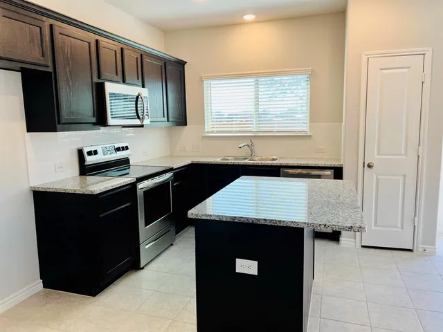 a kitchen with a sink appliances and cabinets