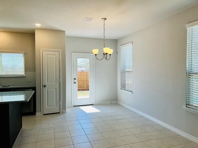 a view of an empty room with window and cabinet