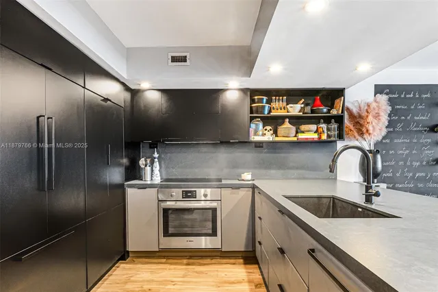 a kitchen with stainless steel appliances granite countertop a refrigerator and a stove top oven