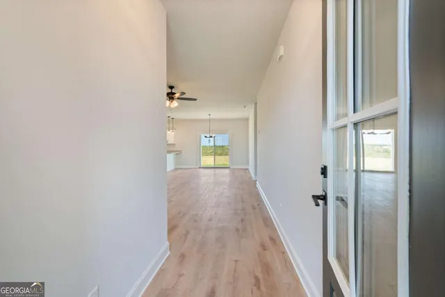 a view of a hallway with wooden floor and staircase