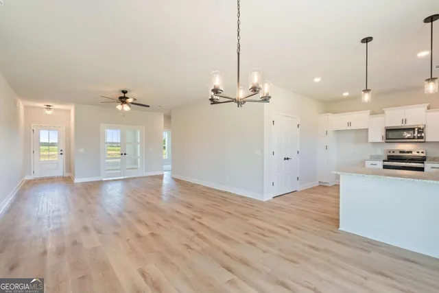a view of an empty room and kitchen view