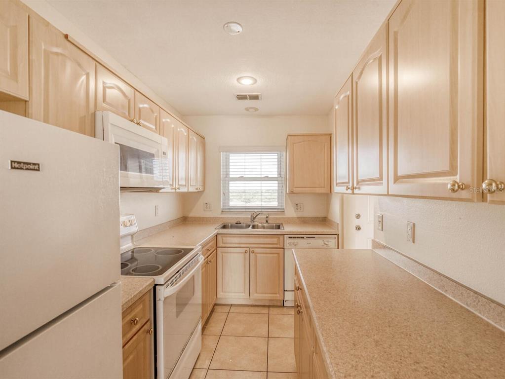 4939 Floramar Terrace, Unit 904 New Port Richey, FL 34652 - Photo 11 of 53 a kitchen with stainless steel appliances granite countertop a sink and cabinets