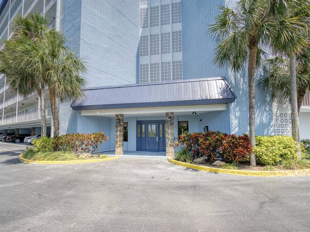 4939 Floramar Terrace, Unit 904 New Port Richey, FL 34652 - Photo 2 of 53 a front view of a house with lots of green space
