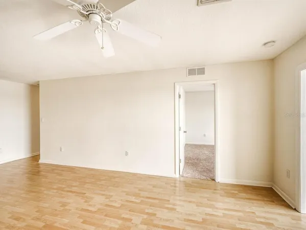 an empty room with a window and a fan