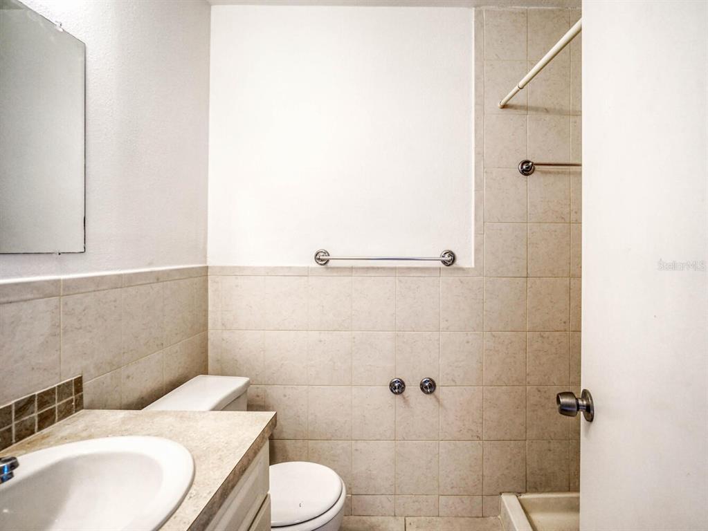 4939 Floramar Terrace, Unit 904 New Port Richey, FL 34652 - Photo 27 of 53 a bathroom with a sink a toilet and shower