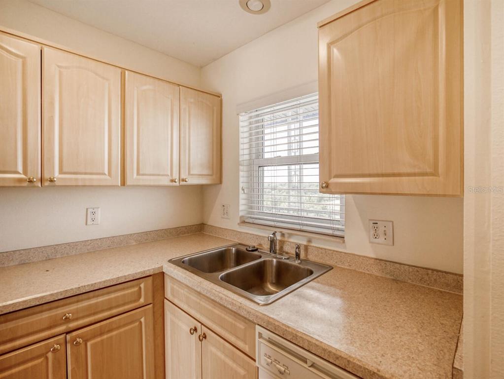 4939 Floramar Terrace, Unit 904 New Port Richey, FL 34652 - Photo 7 of 53 a kitchen with a sink cabinets and window