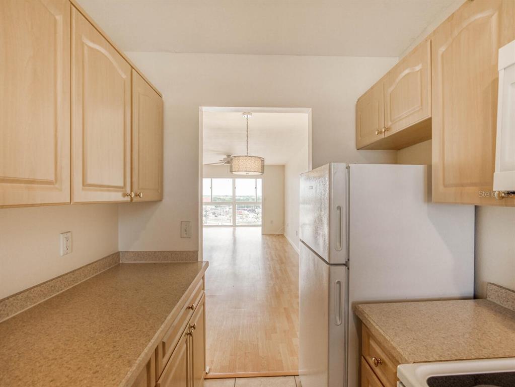 4939 Floramar Terrace, Unit 904 New Port Richey, FL 34652 - Photo 10 of 53 a kitchen with stainless steel appliances granite countertop a refrigerator a sink and white cabinets