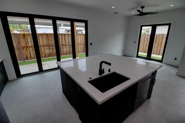 a kitchen with a sink and wooden floor