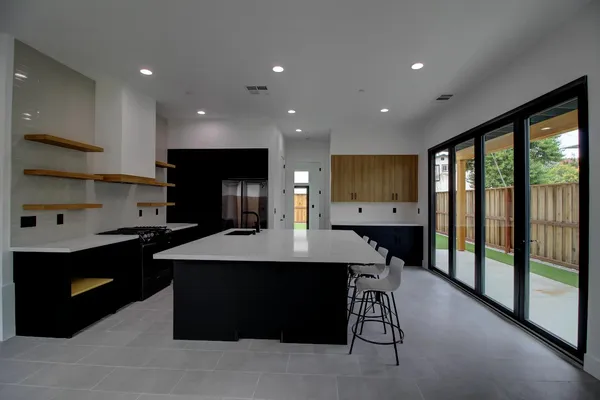 a view of a kitchen with kitchen island a counter top space a sink and cabinets