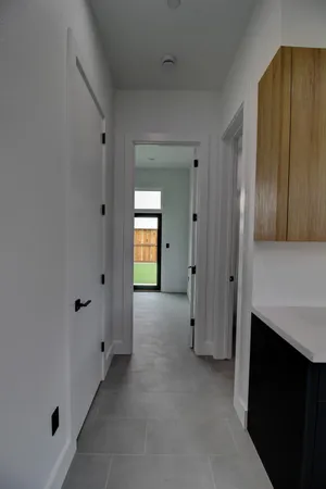 a view of an empty room with closet and mirror