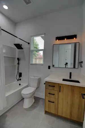a bathroom with a sink toilet a mirror and bathtub