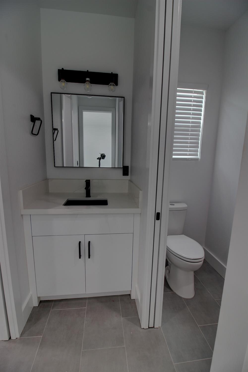 1526 3rd Street Escalon, CA 95320 - Photo 36 of 44 a bathroom with a toilet a sink and mirror