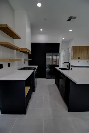 a kitchen with stainless steel appliances a sink stove and cabinets