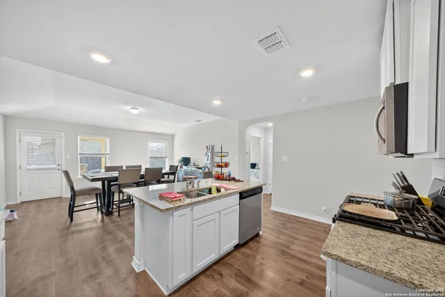 a open kitchen with stainless steel appliances granite countertop a stove and a sink