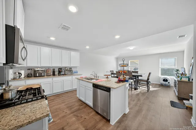 a kitchen with a sink a counter top space appliances and cabinets