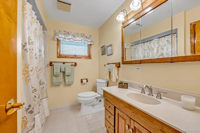 a bathroom with a granite countertop sink mirror vanity and toilet