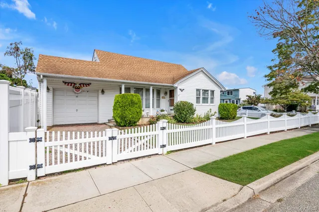 a view of a house with wooden fence next to a yard