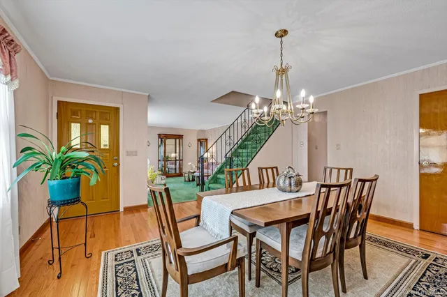 a view of a dining room with furniture wooden floor and chandelier