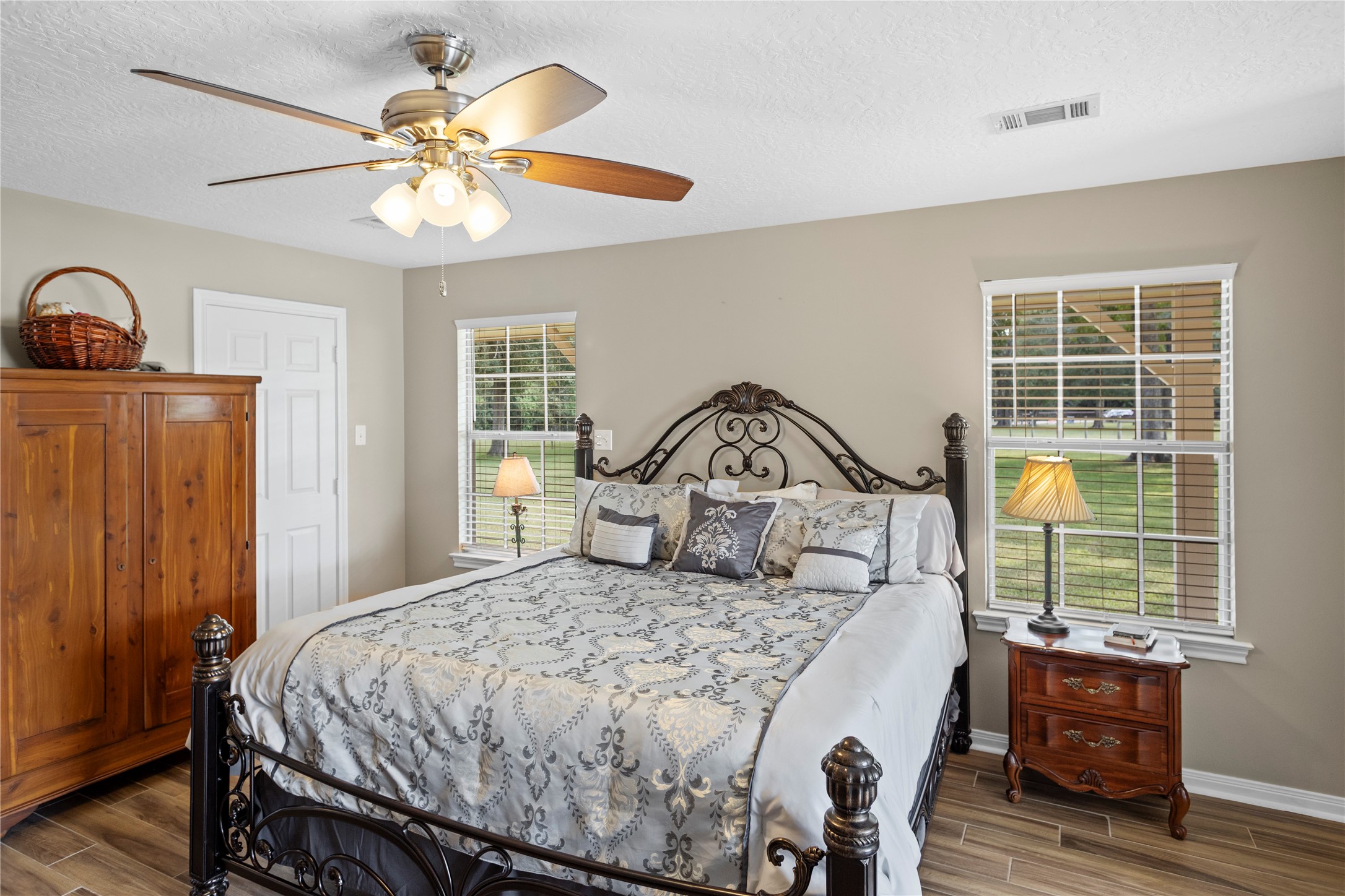 7875 Willys Road New Waverly, TX 77358 - Photo 18 of 45 a bedroom with a bed a chandelier and a dresser