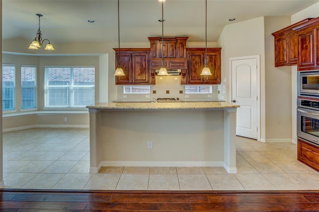 1180 Ranch Gate Lane Frisco, TX 75036 - Photo 18 of 40 a kitchen with stainless steel appliances granite countertop a stove a sink and a refrigerator
