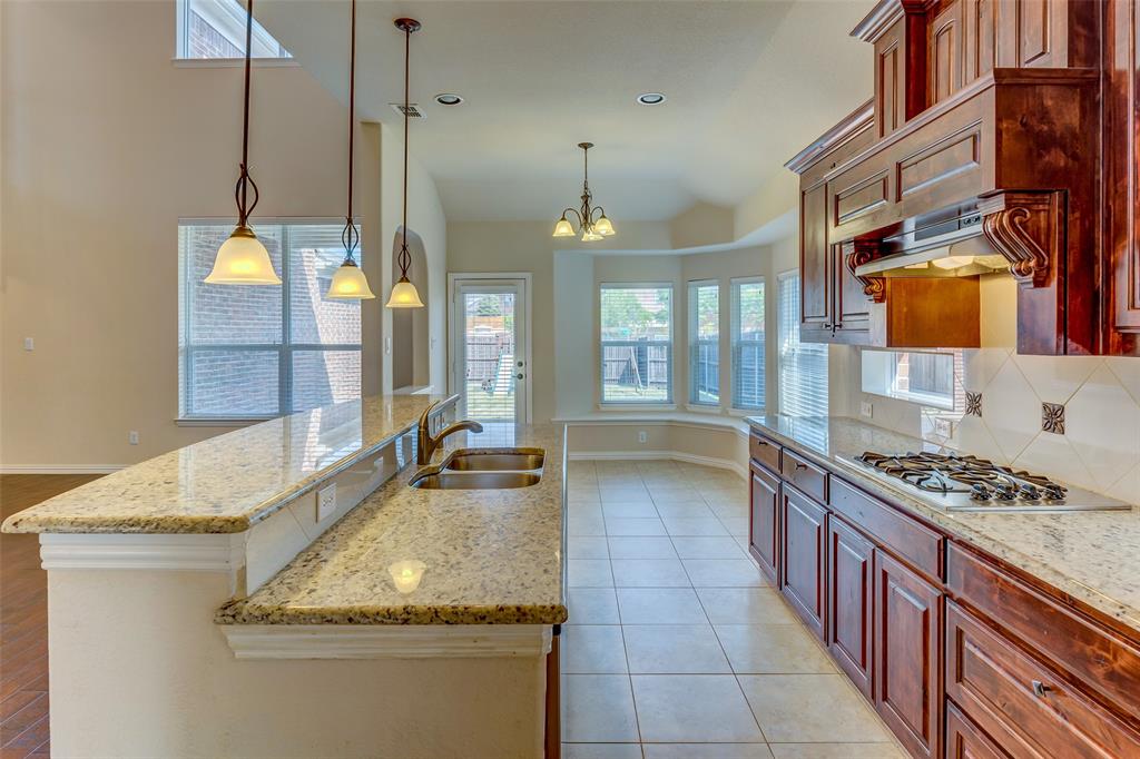 1180 Ranch Gate Lane Frisco, TX 75036 - Photo 20 of 40 a kitchen with stainless steel appliances granite countertop a sink stove and cabinets