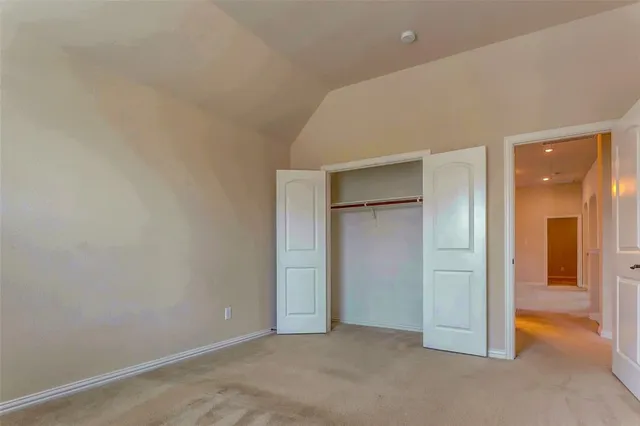 an empty room with closet and a bathroom