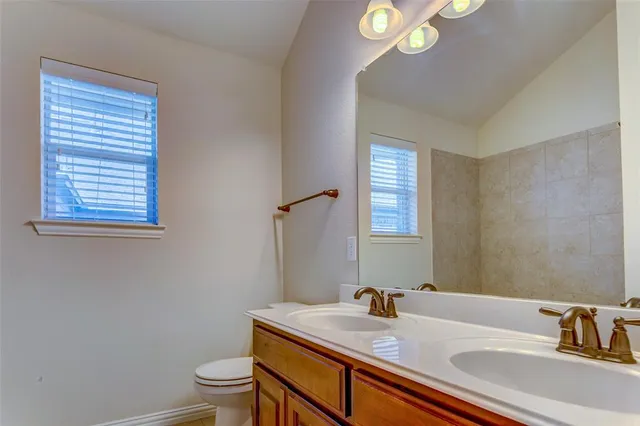 a bathroom with a sink a toilet and a mirror
