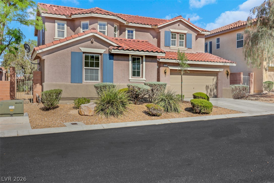 10328 Hawk Ravine Street Las Vegas, NV 89178 - Photo 1 of 55 A well-maintained facade with terracotta roof tiles and mature landscaping presents inviting curb appeal.