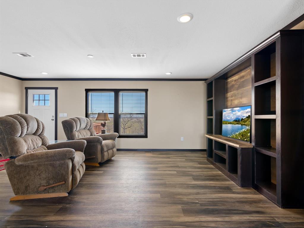 3760 Dewebber Road Bowie, TX 76230 - Photo 25 of 35 a living room with furniture a window and wooden floor