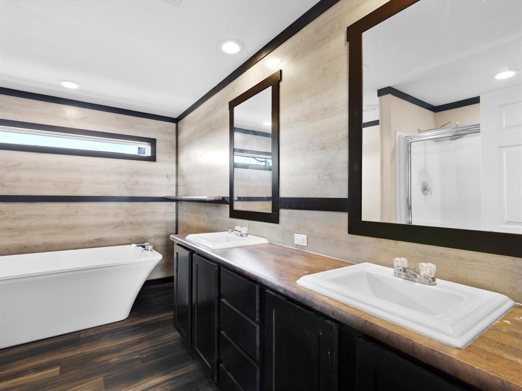 3760 Dewebber Road Bowie, TX 76230 - Photo 26 of 35 a bathroom with a double vanity sink and a large mirror