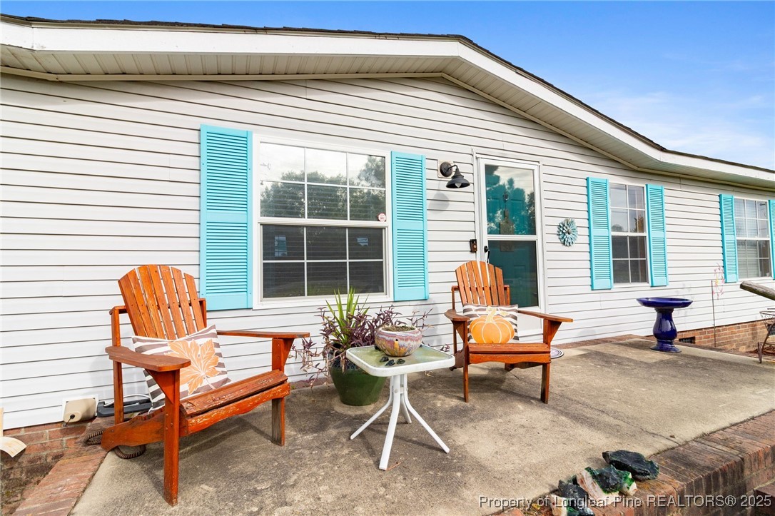 3376 Wade-Stedman Road Wade, NC 28395 - Photo 33 of 35 a outdoor space with a large window and sitting chairs