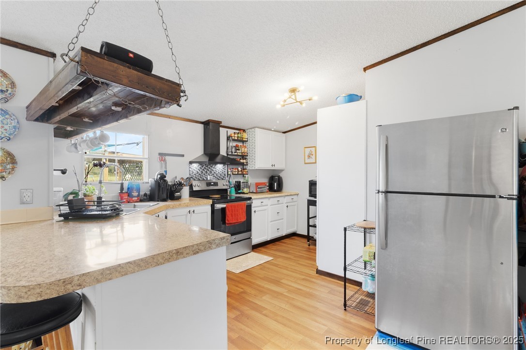 3376 Wade-Stedman Road Wade, NC 28395 - Photo 7 of 35 a kitchen with stainless steel appliances a refrigerator a sink a stove and white cabinets