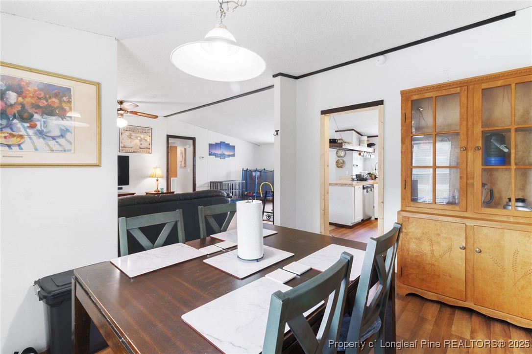 3376 Wade-Stedman Road Wade, NC 28395 - Photo 8 of 35 a view of a dining room with furniture and wooden floor